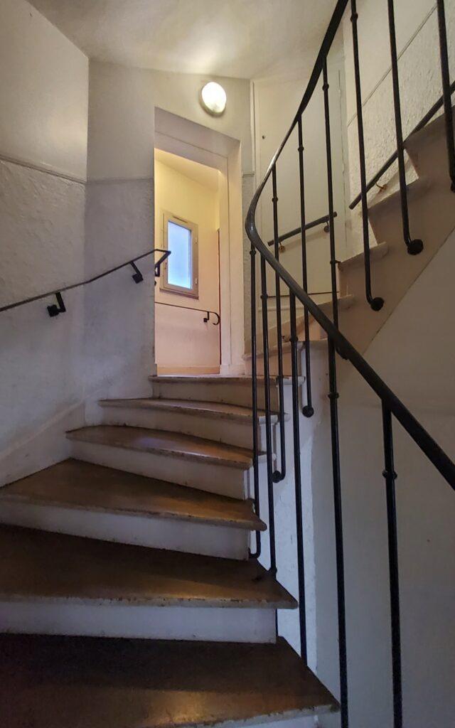 Cage d'escalier état existant, marches bois et garde-corps métallique, 75 rue des Amandiers Paris par Rethink
