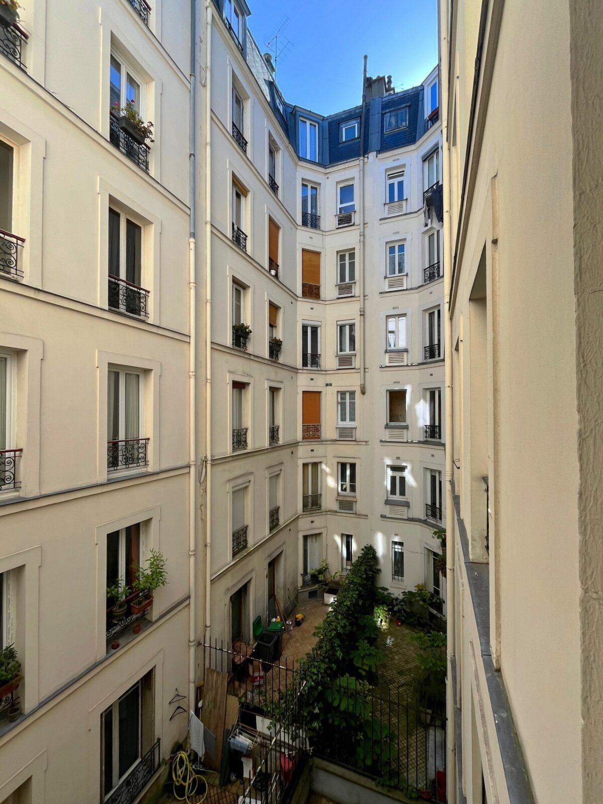 Façades sur cour d'un immeuble haussmannien, balcons en fer forgé et verdure, 92 rue du Mont-Cenis Paris, par Rethink
